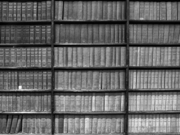 木质书架上的旧书的单色全框深色图像图片下载