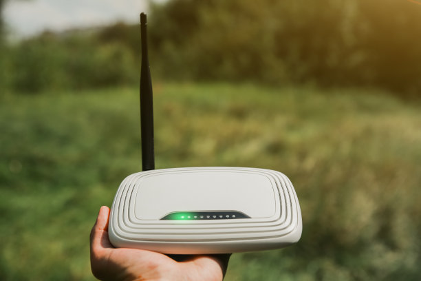 人类在大自然中寻找无线信号。一个人迷路了，手里拿着路由器在寻找网络连接。现代技术的概念。夏季森林照片。图片下载