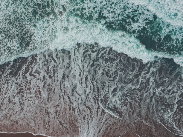 鸟瞰图海浪与泡沫在沙滩上。无人驾驶飞机的照片图片下载