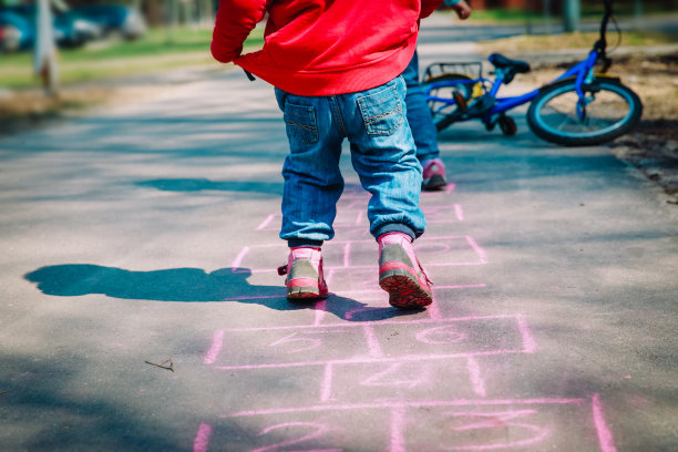 小女孩在操场上玩跳房子，为孩子们做户外活动图片下载