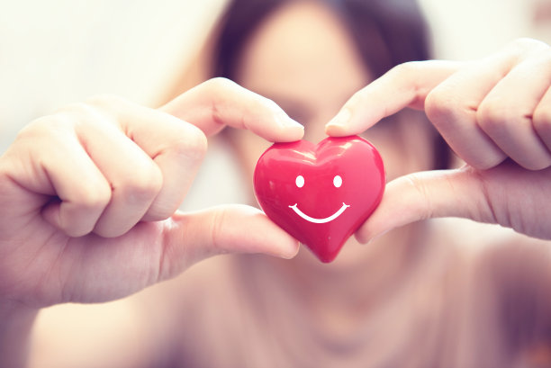 女人的手牵着微笑红心。情人节爱情，医疗医学理念。图片下载