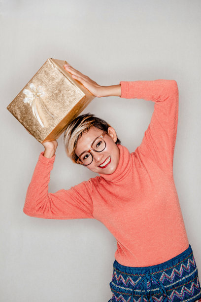 亚洲女性手里拿着礼物时的微笑和幸福的照片。专注于脸图片下载