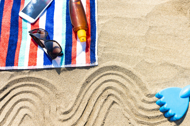 沙滩毛巾，手机和防晒霜图片下载