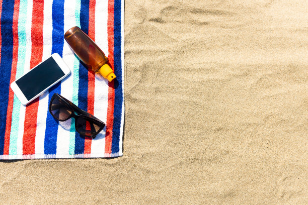 沙滩毛巾，手机和防晒霜图片下载