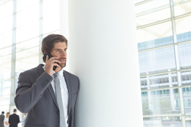商人在大堂办公室用移动电话交谈图片下载