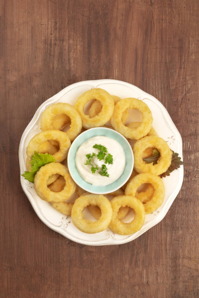 头顶上的一张鱿鱼圈和蛋黄酱的照片，背景是黑色的乡村木制的，还有一个文字的地方图片下载