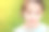 幸福微笑的小白人女孩在耳环和蓝色衬衫在温暖的绿色背景的特写肖像图片下载
