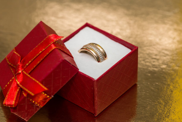 金戒指在红色礼品盒金色背景图片下载