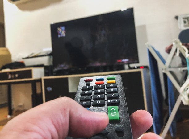 左手拿着电视遥控器图片下载