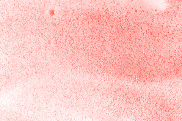 活珊瑚色样本。2019年的颜色。肥皂泡沫泡沫的粉红色背景微距接近。图片下载