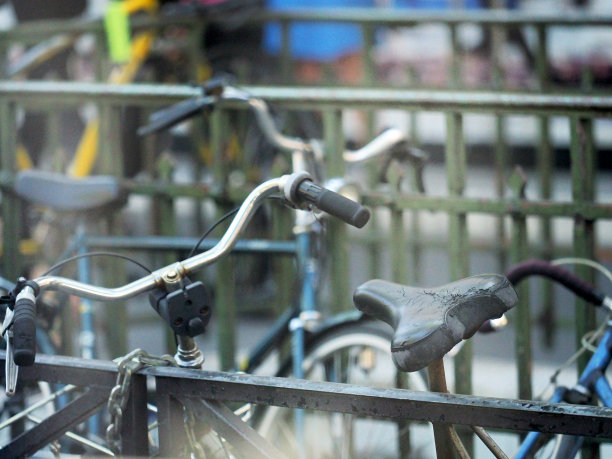 城市交通，旧自行车系在围栏上，街道背景图片下载