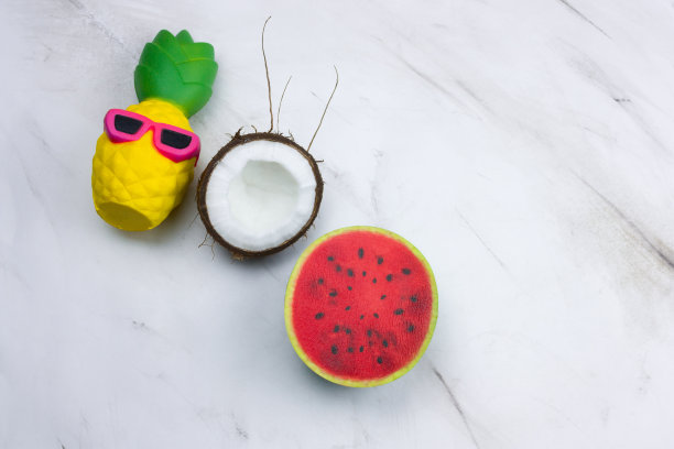 有趣的菠萝玩具在太阳镜，西瓜和椰子在大理石桌上图片下载
