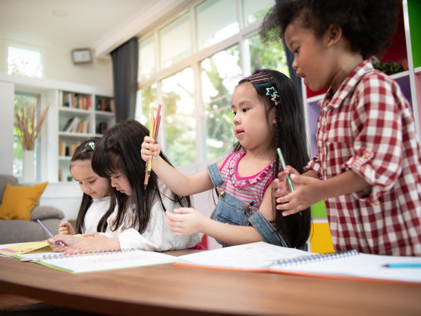 多民族的非洲裔美国人，亚洲和高加索儿童儿童幸福与选择彩色铅笔画满色彩的图片与在客厅或家庭学校教育。图片下载