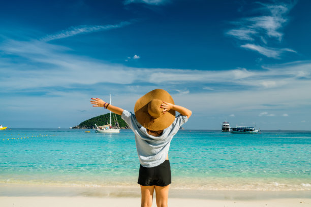 后视图的年轻女子旅行者与帽子放松在米兰岛的海滩上图片下载