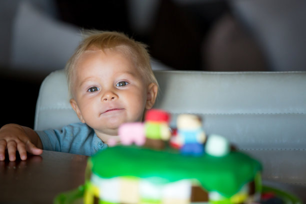 小男孩，庆祝他的一岁生日，吃蛋糕和气球图片下载