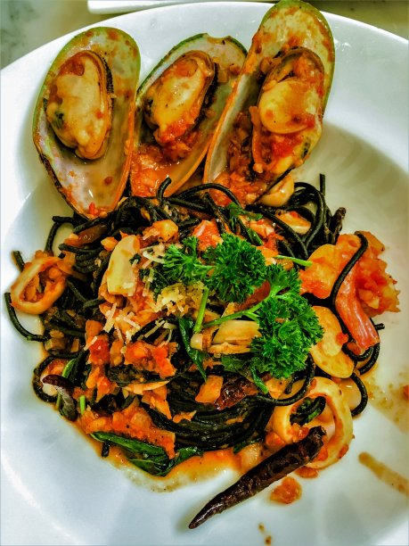 黑意大利面，番茄酱海鲜。黑意大利面，墨鱼汁，虾，贻贝和欧芹图片下载