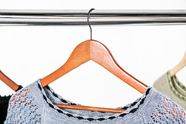 漂亮的针织连衣裙挂在衣架上，挂在明亮的背景上图片下载
