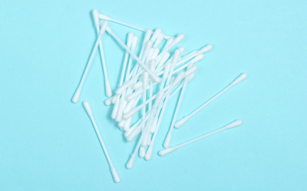 耳朵卫生棉签上蓝色背景。图片下载