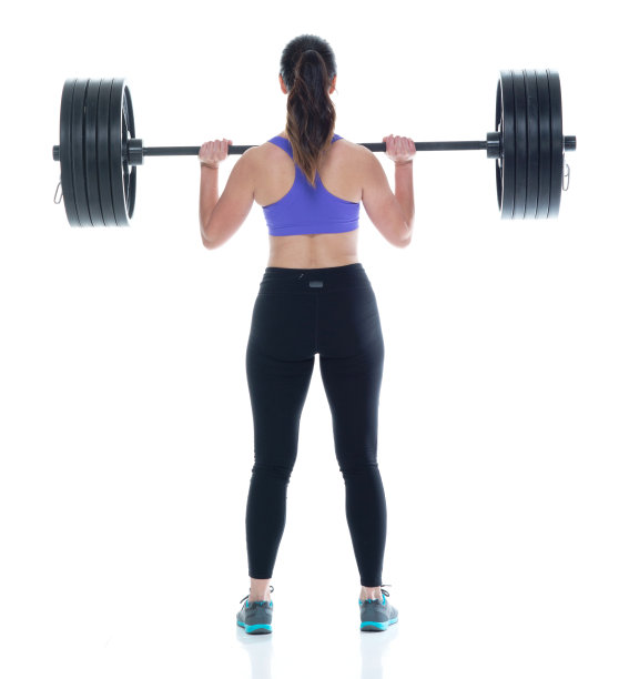 美丽的女性在运动服装举起重物，后视图图片下载