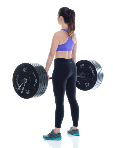 美丽的女性在运动服装举起重物，后视图图片下载