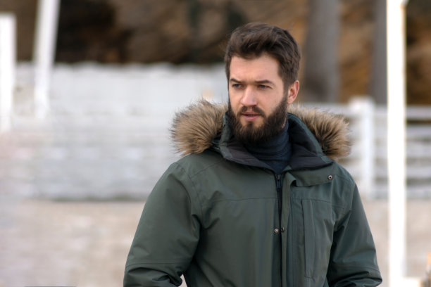 一个留着胡子的帅哥在看远处。图片下载