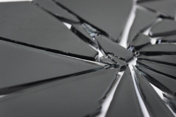 白色背景上破碎的黑色透明玻璃纹理。图片下载