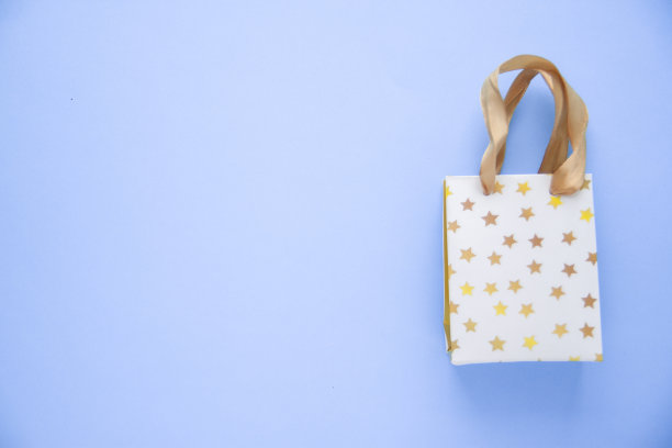 一个蓝色背景的白色购物袋或礼品袋。Copyspase -销售，购买和目前的概念图片下载