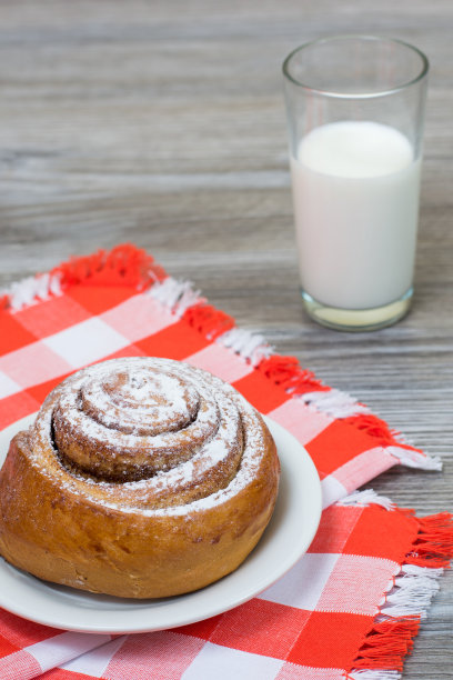 食欲的垂直照片肉桂卷在格子桌布和牛奶杯图片下载