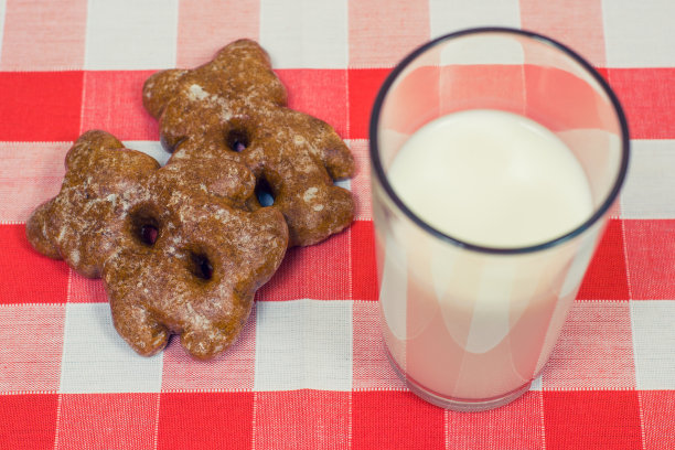 饼干和牛奶在格子桌布上的近距离照片图片下载