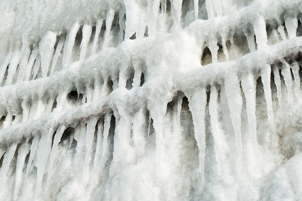 城市里的冬天多雪。冰冷的栏杆。大冰柱的纹理图片下载