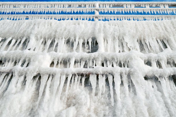 城市里的冬天多雪。冰冷的栏杆。大冰柱的纹理图片下载