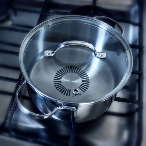 燃气灶上带玻璃盖的沸水不锈钢锅图片下载
