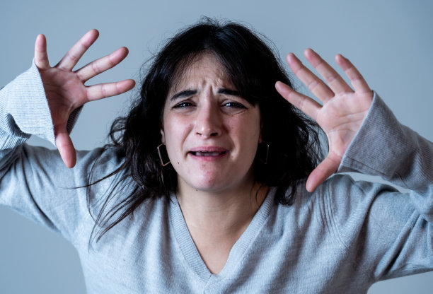 面部表情和情绪。近距离的年轻有吸引力的西班牙女人的肖像与愤怒的脸。看起来很疯狂，大喊大叫，做出愤怒的手势。孤立在喜怒无常的背景。图片下载