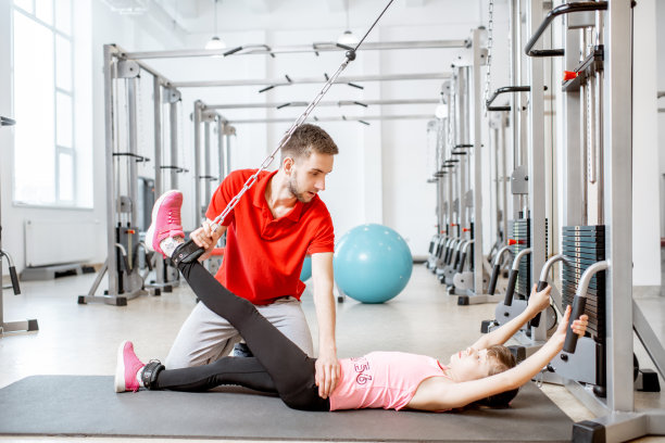 小女孩在健身馆和教练一起锻炼图片下载