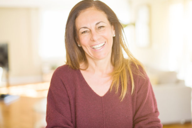 美丽的中年女人在家里微笑图片下载