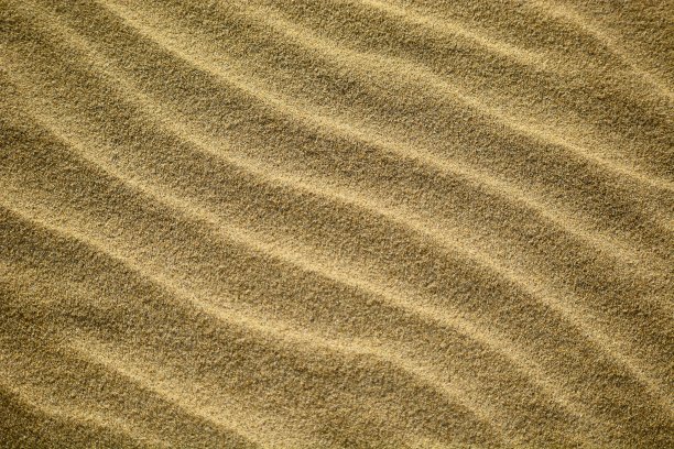 新西兰海滩上的金色沙滩上海浪形成的抽象图案;清晨——美丽的阳光。的背景图片。图片下载