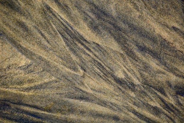 新西兰海滩上的金色沙滩上海浪形成的抽象图案;清晨——美丽的阳光。的背景图片。图片下载