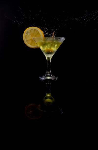 橄榄洒上苦艾酒和柠檬，黑色背景图片下载