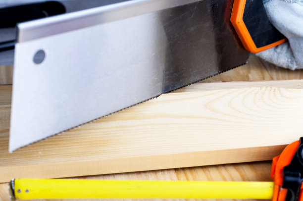 建造或修理房屋的工作。独立的更新改造。使用锯子，工作手套，卷尺。DIY概念，工作场所安全，工人保护图片下载