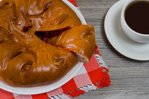 特写俯视图美味的胃口自制樱桃派和一杯茶在木桌上的照片图片下载