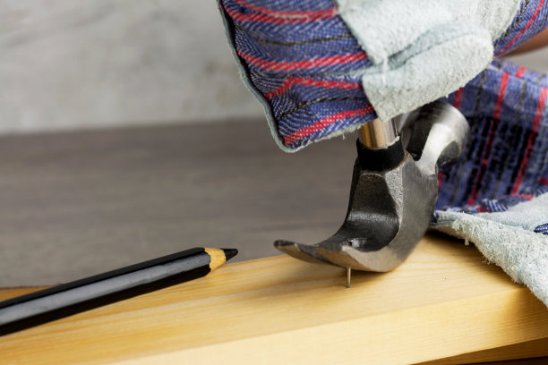 建造或修理房屋的工作。独立的更新改造。使用工作手套和锤子。DIY概念，工作场所安全，工人保护图片下载