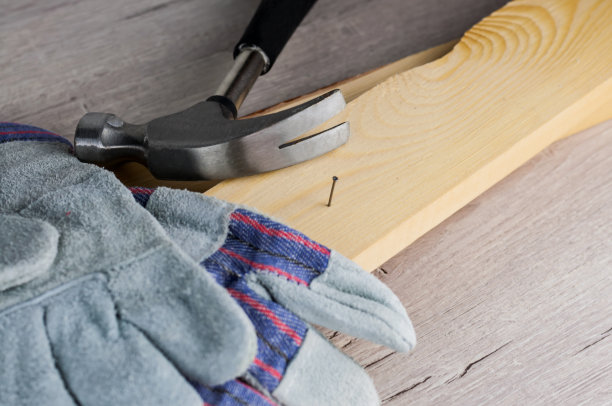 建造或修理房屋的工作。独立的更新改造。使用工作手套和锤子。DIY概念，工作场所安全，工人保护图片下载