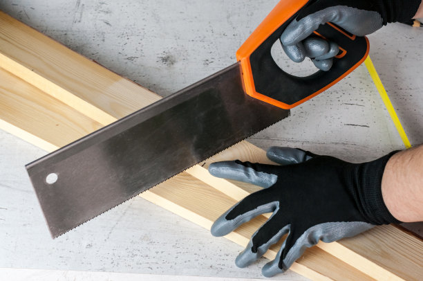 一个人用铅笔在木条上做记号，以便用锯子进一步加工。Diy家居概念图片下载