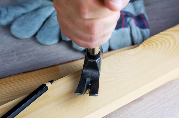 建造或修理房屋的工作。独立的更新改造。使用工作手套和锤子。DIY概念，工作场所安全，工人保护图片下载