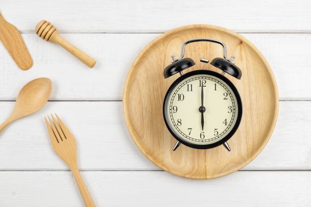 俯视图的经典古董闹钟在木板上与勺子和叉子图片下载