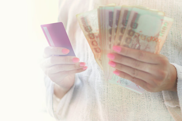 亚洲女商人手里拿着钱计划投资或支付和信用卡图片下载
