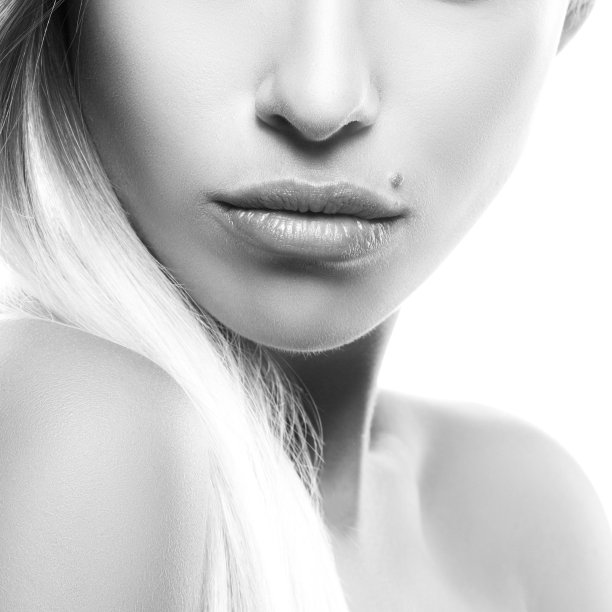 女孩部分的脸，性感的女孩嘴唇，肩膀，干净的皮肤，自然裸妆。黑色和白色图片下载