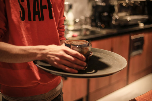 年轻的咖啡师在咖啡馆工作。准备倒咖啡图片下载