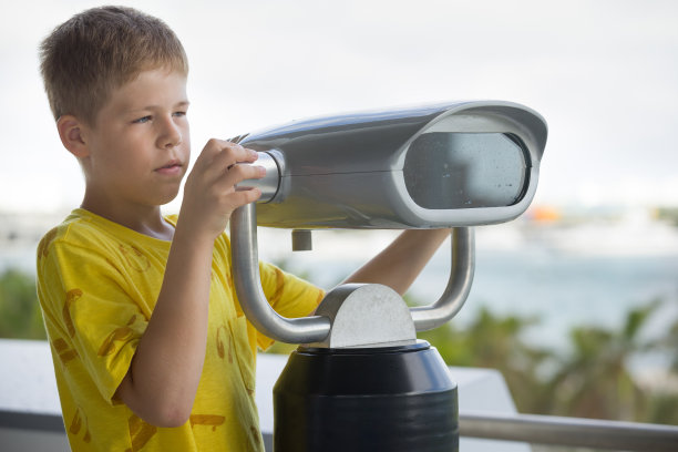 可爱的小男孩的肖像与旅游双筒望远镜望向远方。儿童探索和望远镜看。旅游的双眼。图片下载