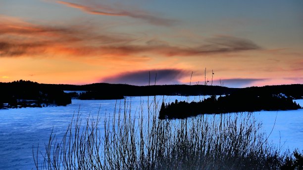 日落雪河周围的森林与岛屿图片下载
